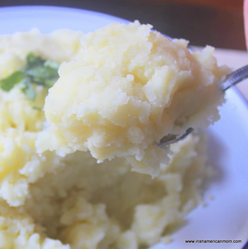 A spoonful of floury Irish mashed potatoes taken from a serving bowl