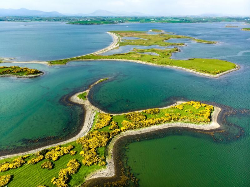 Green islands dotted in a bay of aqua green ocean waters