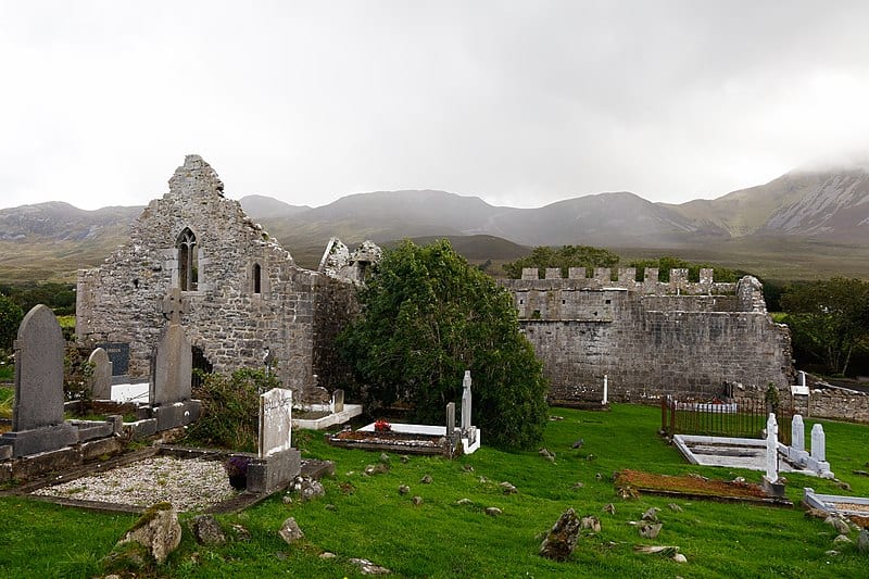 A ruined church beside foggy hills