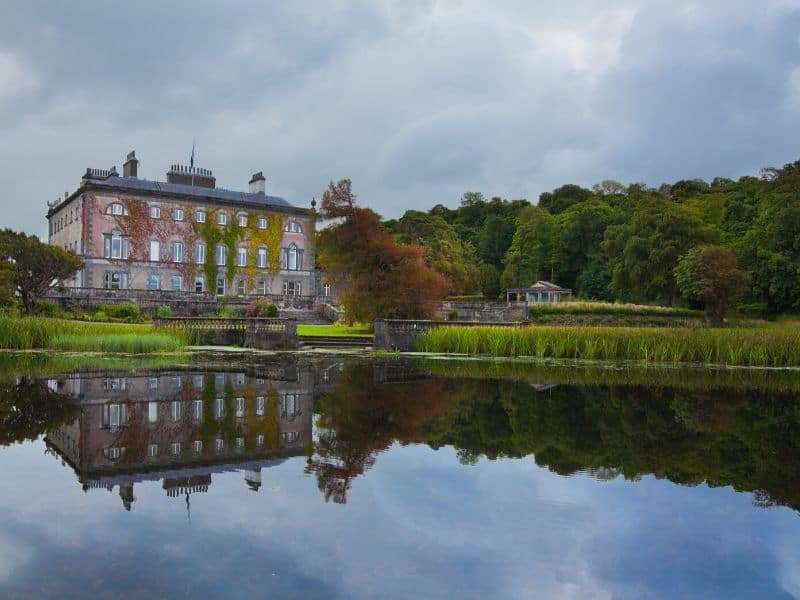 A large country house reflecting in a nearby lake