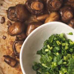 Adding chopped fresh parsley to sauteed mushrooms