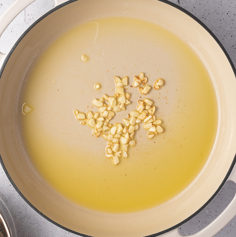 Hot olive oil in a skillet with minced chopped garlic | Irish American Mom Garlic in a pan of olive oil for frying