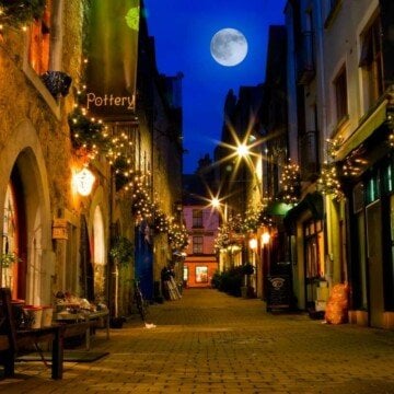 A full moon between the buildings of an Irish street