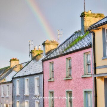 A rainbow over rooftops of brightly painted houses