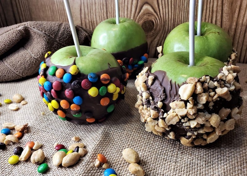 Halloween cooking for kids included making chocolate dipped apples | Irish American Mom Four chocolate dipped and decorated green apples with lollipop sticks for serving