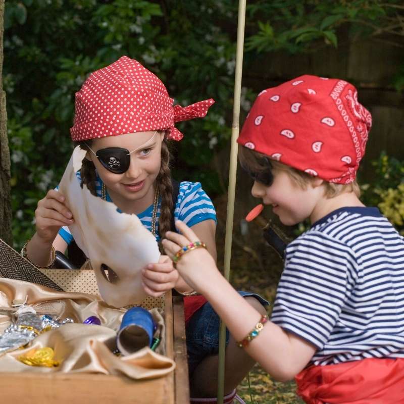 Homemade pirate costumes for Halloween | Irish American Mom Two children wearing striped shirts and red pirate bandanas examine a treasure map