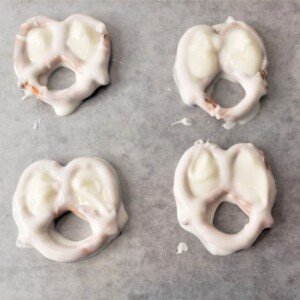 Halloween pretzels covered in white chocolate on parchment paper