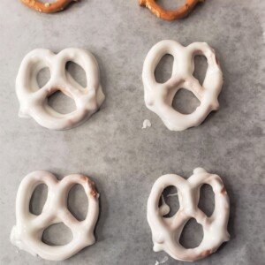 White chocolate coated pretzels on a parchment lined tray