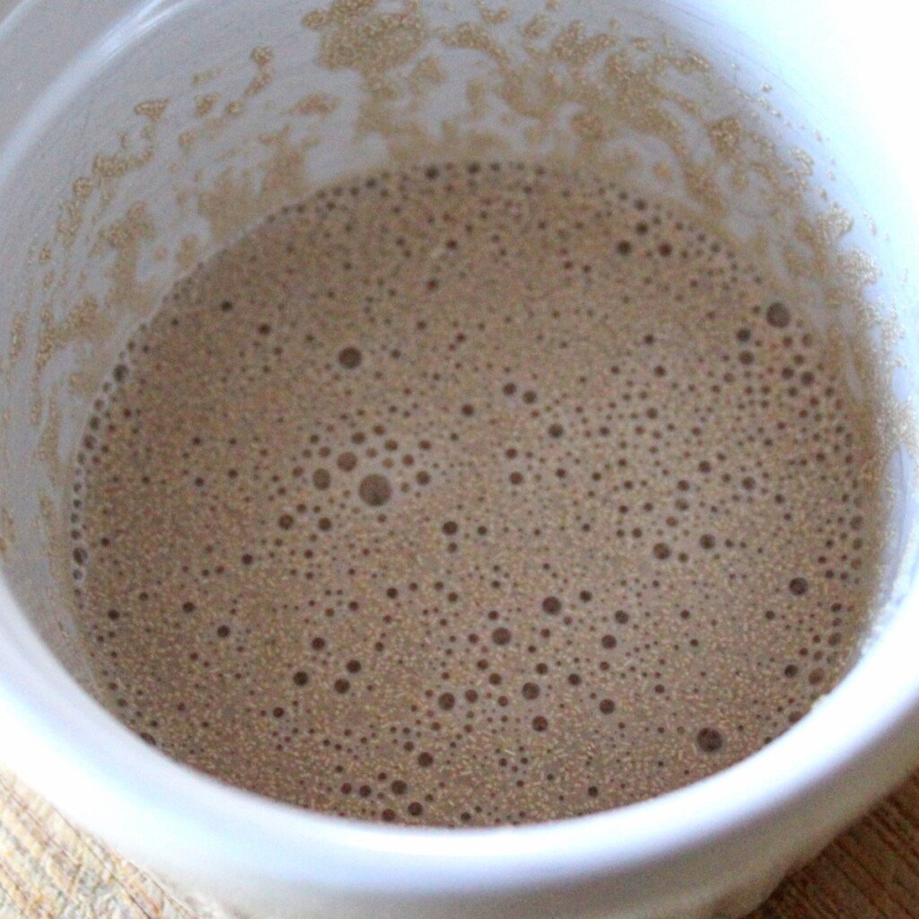 Yeast mixed with milk and sugar bubbling in a ramekin dish