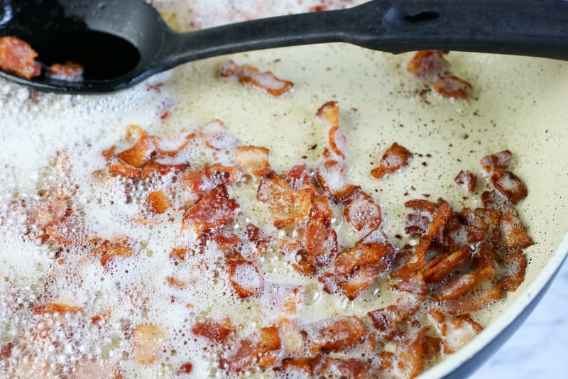 Bacon lardons cooking in oil and butter. | Irish American Mom Chopped bacon pieces in a skillet frying in butter and oil