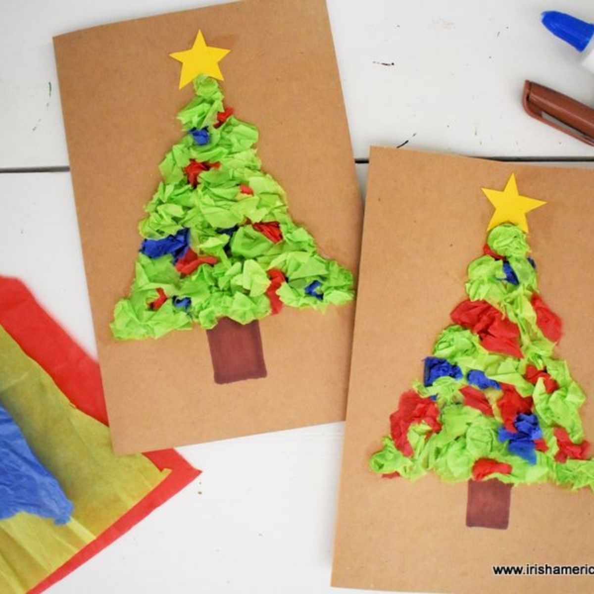 Brown card stock cards with tissue paper Christmas Tree motifs beside some tissue paper sheets