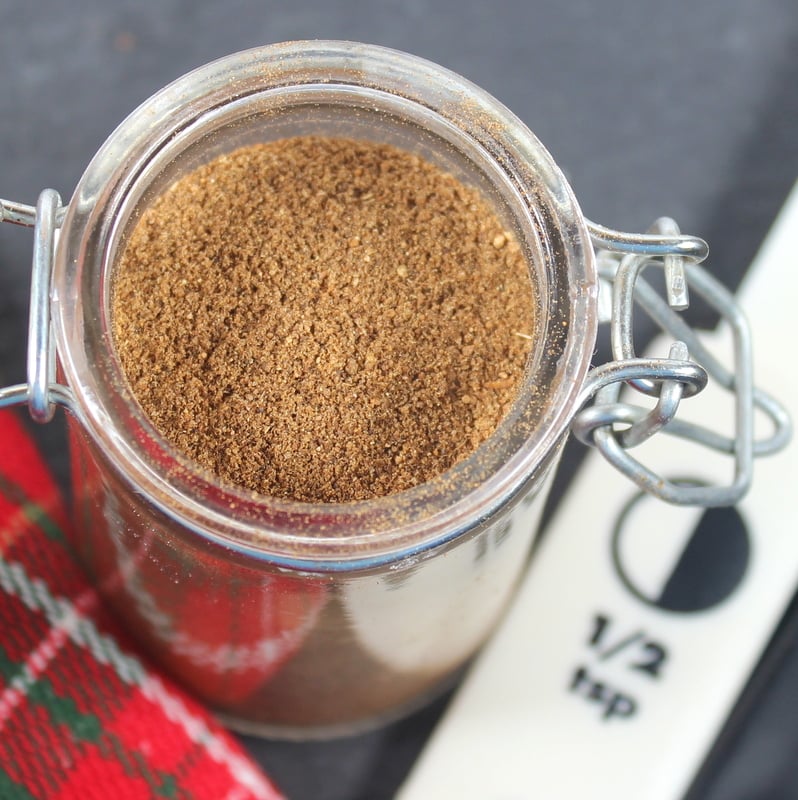 Aerial view of a small mason jar of brown mixed spice for baking