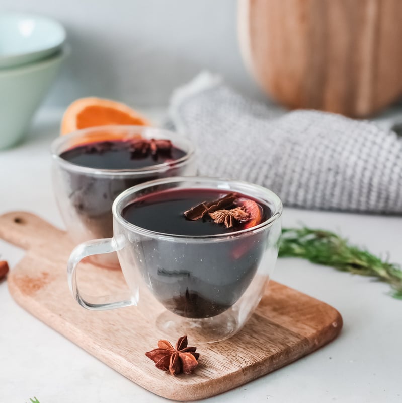 Two glasses of red mulled wine | Irish American Mom Red mulled wine in two glass cups on a wooden cutting board