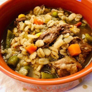 Beef barley stew in an orange bowl