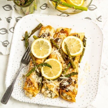 Asparagus and chicken pancakes on a plate with lemon slices as garnish