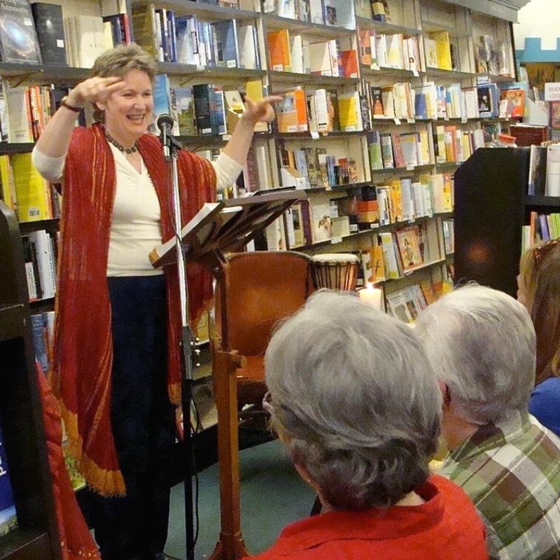 A woman at a lectern teaching a class in a book store