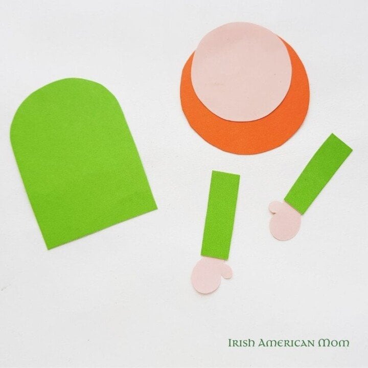 Making the face and arms for a leprechaun bookmark | Irish American Mom Green arch shape, pink and orange circles, and paper arms