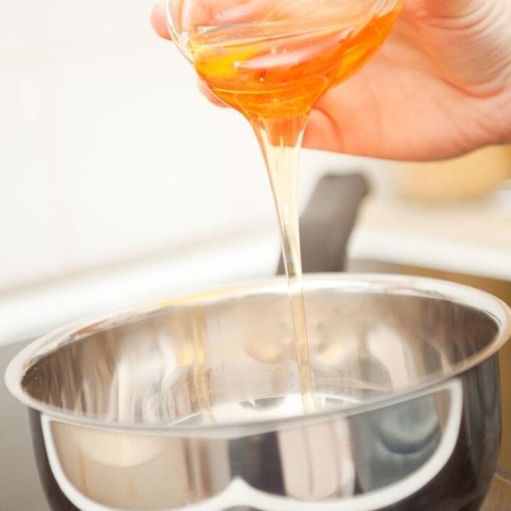 Pouring golden syrup into a saucepan | Irish American Mom Golden syrup being poured from a glass bowl into a saucepan