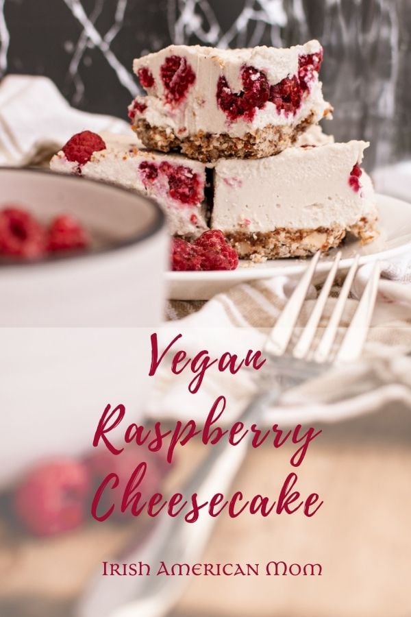 Raspberry cheesecakes on a plate | Irish American Mom Raspberry cheesecakes on a plate with a bowl of raspberries and a fork in the foreground with text