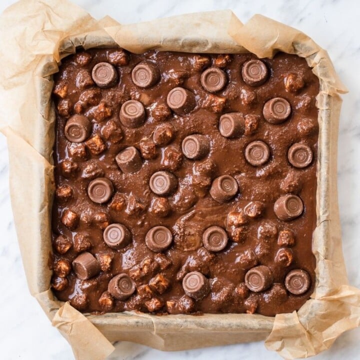 Rolo Rocky Roads in a lined square baking pan | Irish American Mom A parchment paper lined square baking pan with a chocolate candy no bake cake