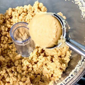 Using an ice cream scoop to form cake balls using cake crumbs