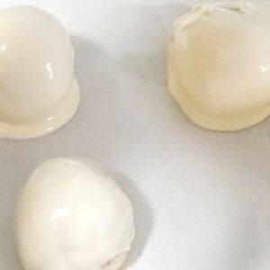 White chocolate covered cake truffles on parchment paper