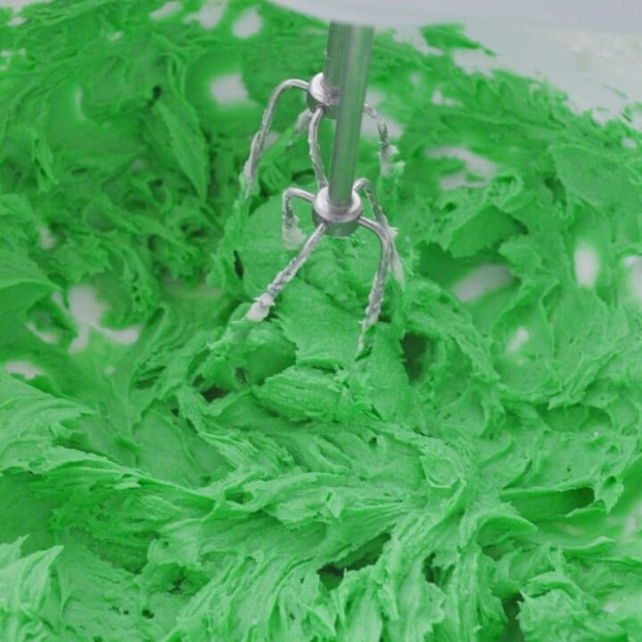 Green food coloring in frosting for Irish brownies | Irish American Mom Green food coloring being mixed into butter cream frosting