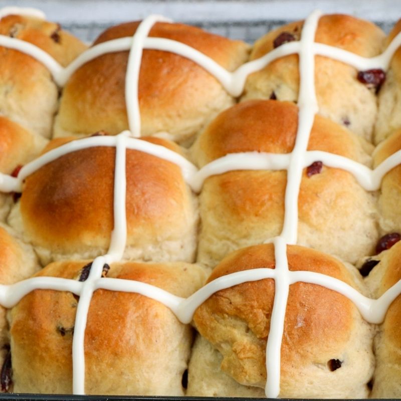 Iced crosses on bread machine hot cross buns | Irish American Mom Icing crosses on a tray of golden baked buns