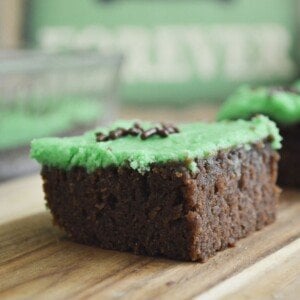 Brownie with green frosting on a wooden board
