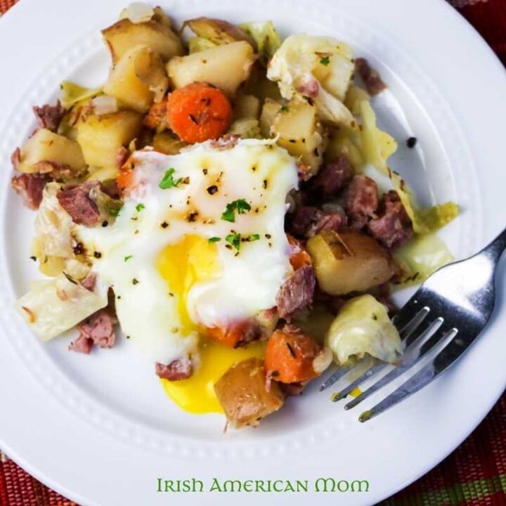 Left over corned beef hash | Irish American Mom Corned beef hash with a soft cook egg on a white plate with a fork