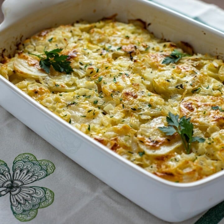 Golden brown potatoes and cheddar cheese in a casserole for Irish scalloped potatoes | Irish American Mom Golden baked scalloped potatoes in a casserole
