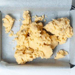 Unbaked dough tipped into a lined baking tray