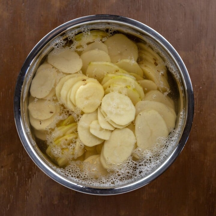 Sliced potatoes in a bowl of water | Irish American Mom Sliced peeled potatoes in a bowl of water