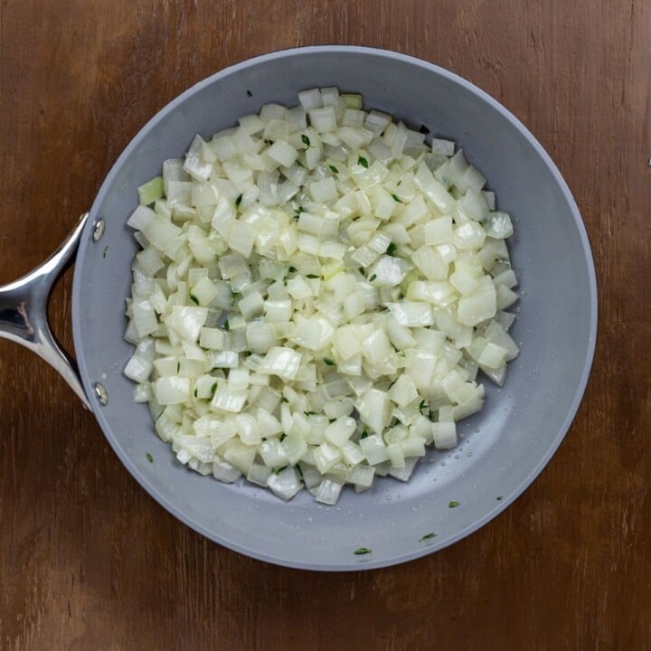 diced onion and thyme in a skillet for Irish style scalloped potatoes | Irish American Mom Diced onion and thyme in a skillet