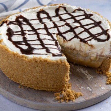 A slice removed from a caramel, banana and cream pie