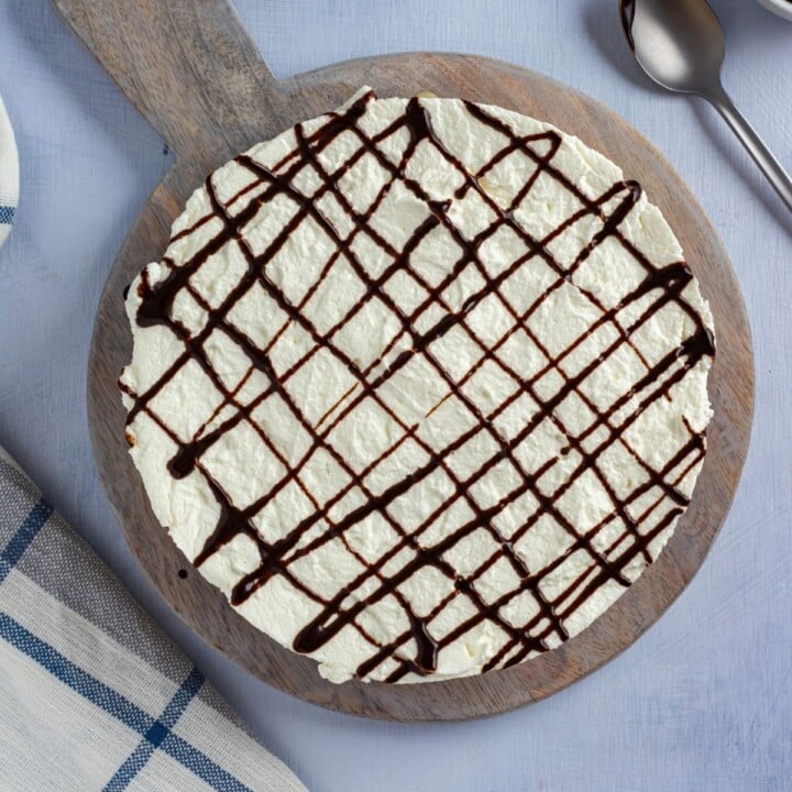 Chocolate drizzle on top of a banoffee pie | Irish American Mom Chocolate zig zags on top of a pie with a whipped cream top layer