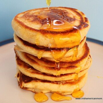 Honey dripping over a stack of golden pancakes