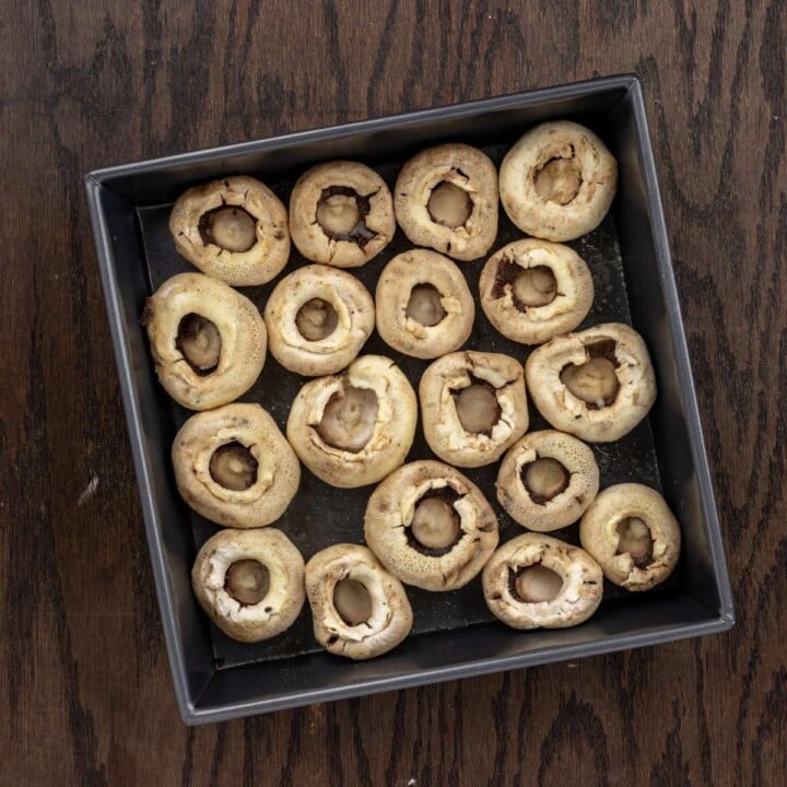 Mushrooms in a baking pan for stuffed mushroom recipe | Irish American Mom Destemmed mushrooms in a baking pan