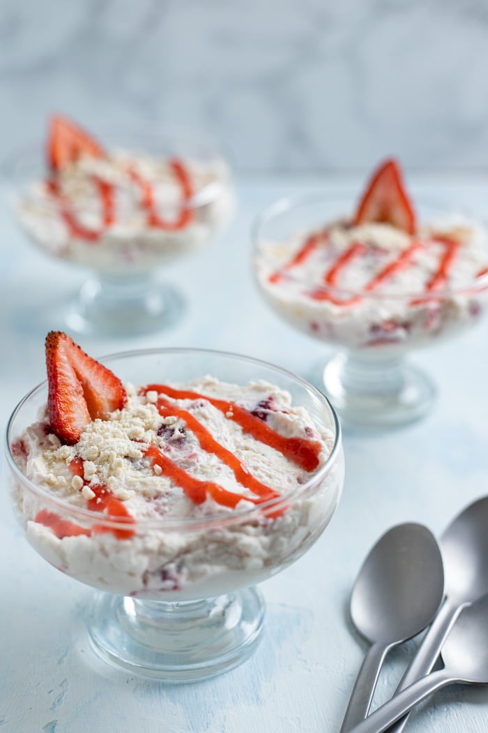 Strawberry desserts in glass dishes with spoons