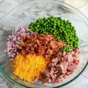 Peas, ham, bacon, cheese and onion in a bowl