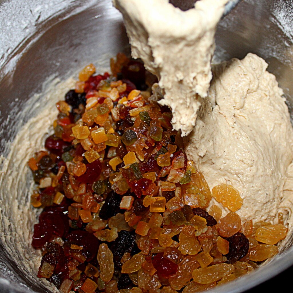 Adding dried fruit to dough in a bowl