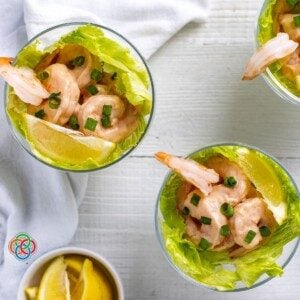 Looking down on bowls of prawn cocktail with lemon wedges