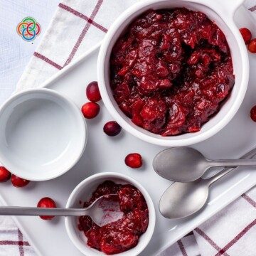 Bowls of cranberry sauce on a tray with spoons