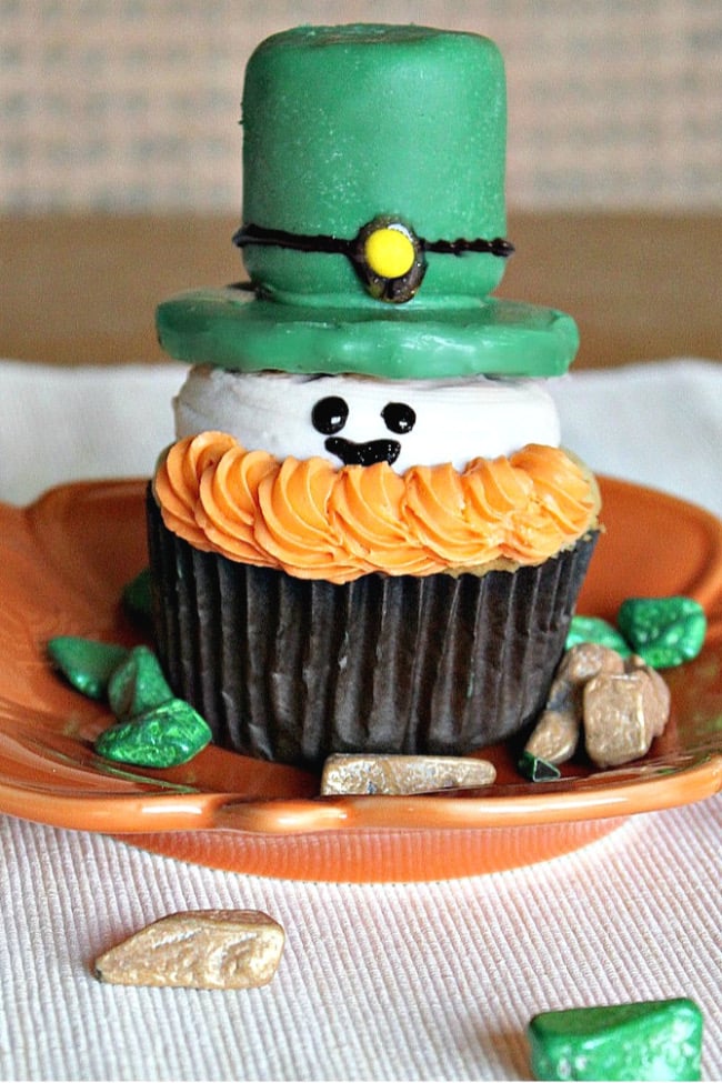 Leprechaun cupcake with orange frosting bearch and green marshmallow hat | Irish American Mom Leprechaun cupcake