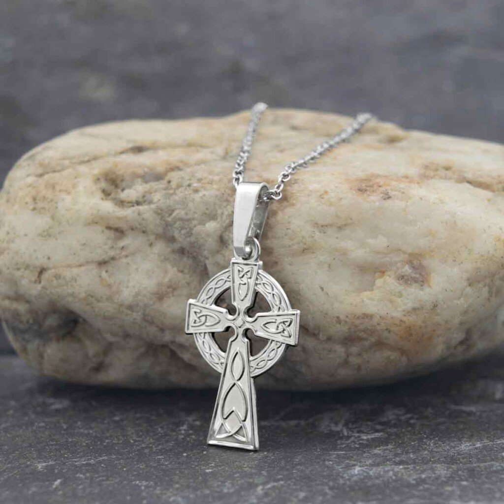 Silver Celtic Cross with Celtic knotwork design | Irish American Mom Celtic cross necklace on a rock