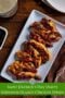 White platter of caramelized Guinness glazed chicken strips on a wooden table with dipping sauce, labeled Saint Patrick’s Day Party Guinness Glazed Chicken Strips with Irish American Mom branding.