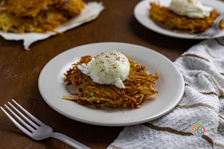 Poached eggs served over potato hash cakes | Irish American Mom Poached egg on a crisp potato pancake