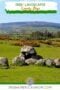 Stone monument in a rural landscape with text banners