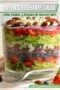 Layered blueberry salad in a clear glass jar with greens, berries, pecans, and onions; overlay text reads 'Layered Blueberry Salad' and 'Fresh, colorful, & delicious for your next party!'