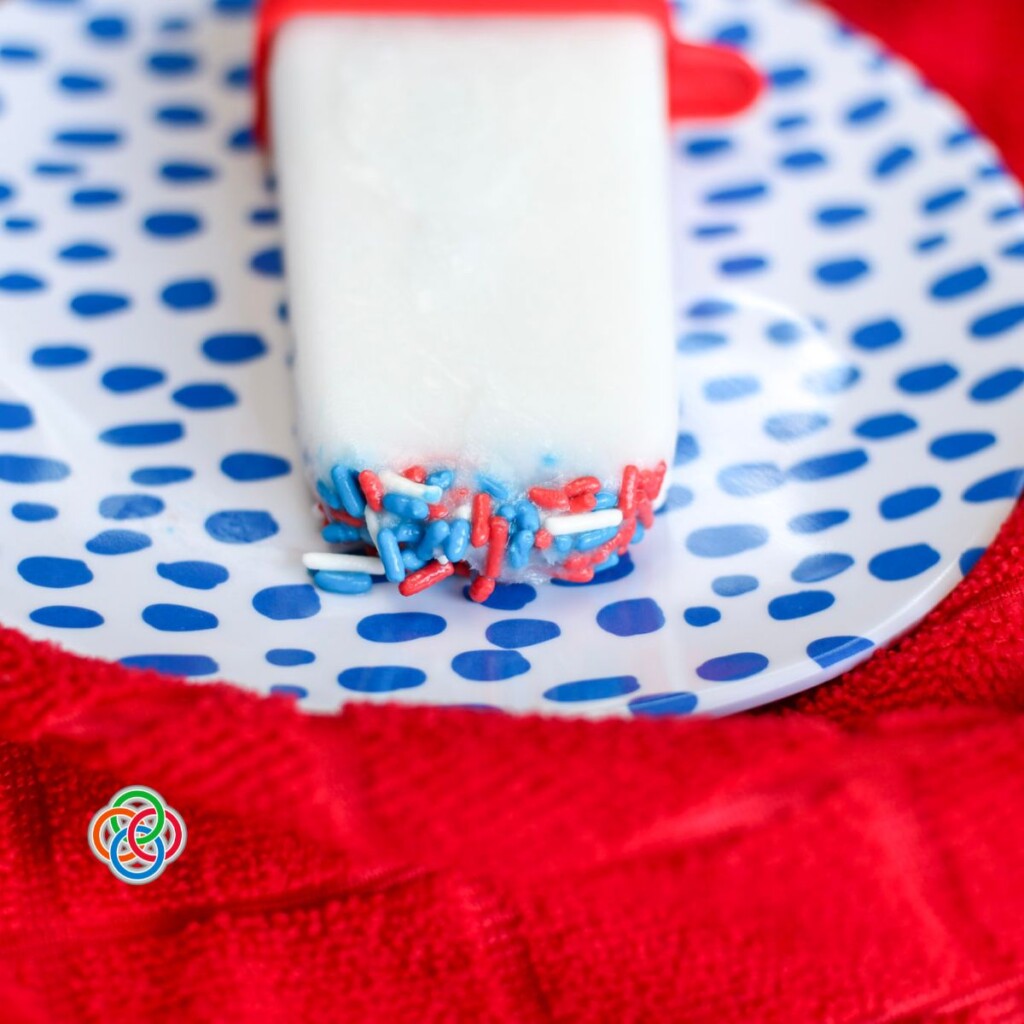 Simple patriotic popsicles | Irish American Mom Red whtie and blue sprinkles on a white popsicle